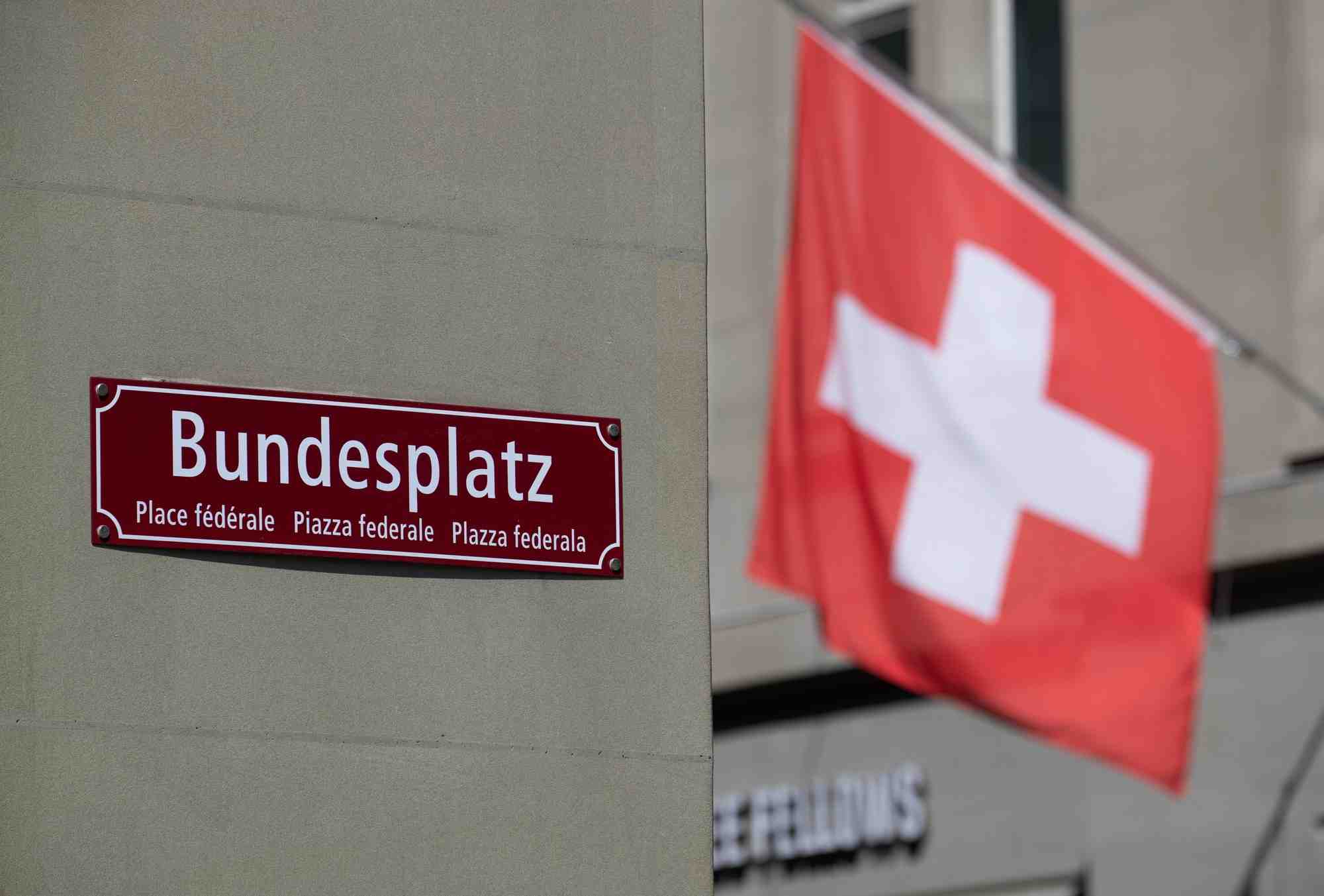 Un drapeau suisse devant le panneau de la place federale