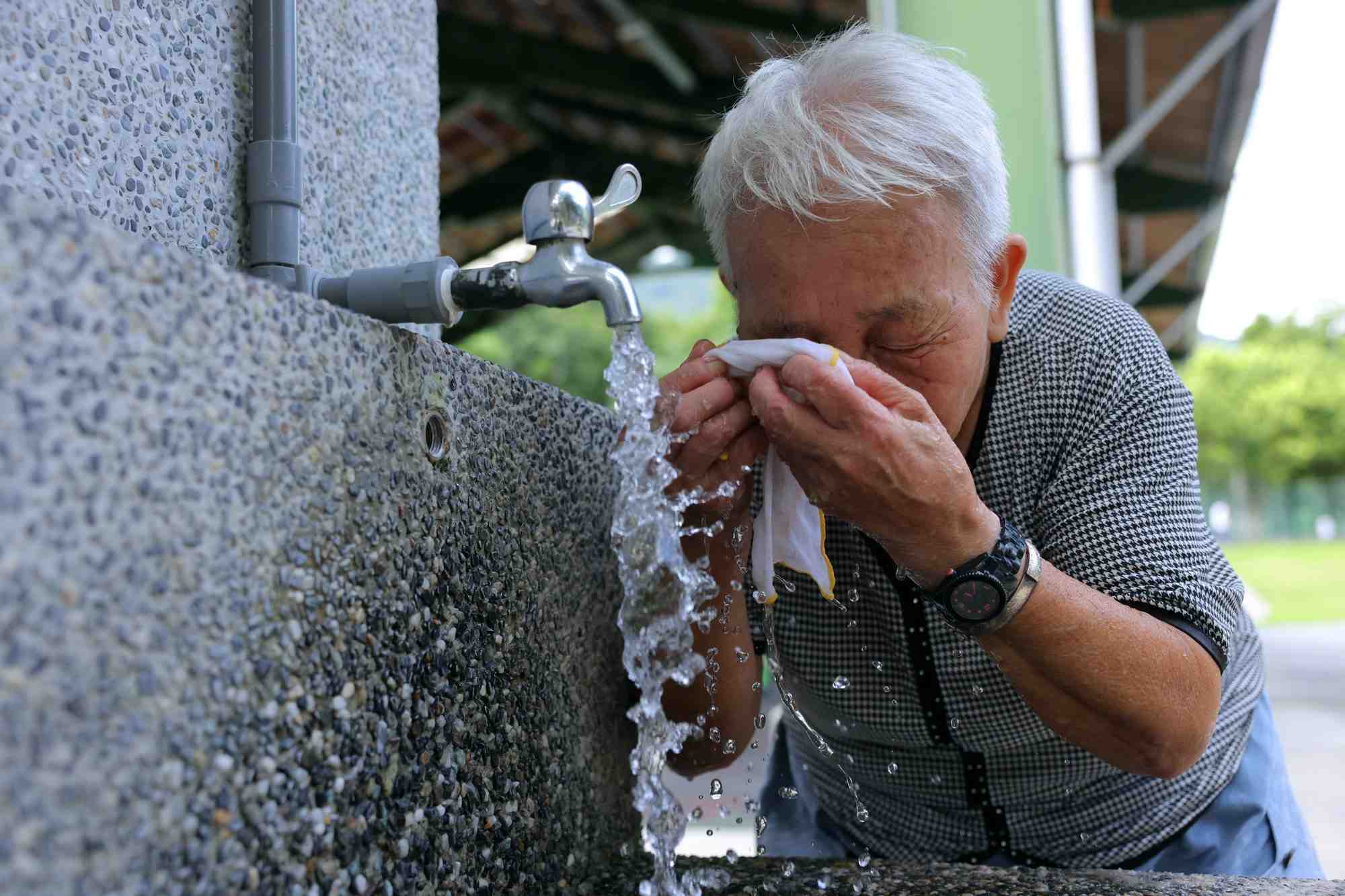 Une personne agee se rafraichie lors d'une journee de canicule