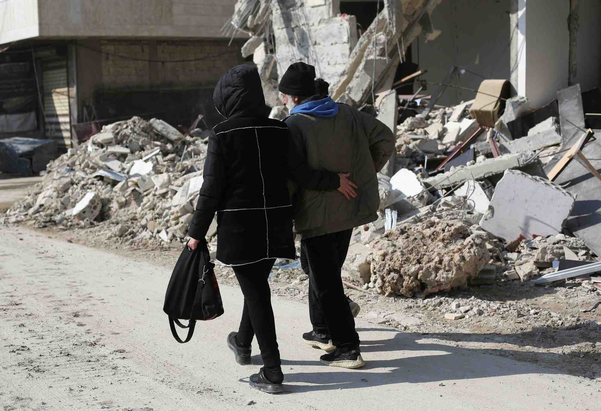 Des gens marchent pres des batiments endommages par un tremblement de terre a jableh, en syrie