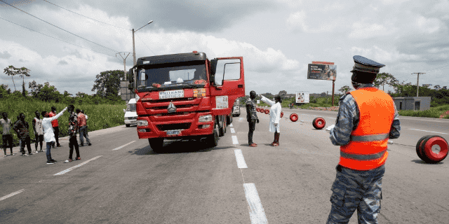 Des agents du ministre de la santé soumettant les camionneurs au contrôle de température à Abidjan, le 30 mars 2020. Les autorités ivoiriennes avaient auparavant réduit le déplacement entre les villes pour limiter la propagation de l'épidémie de coronavirus.