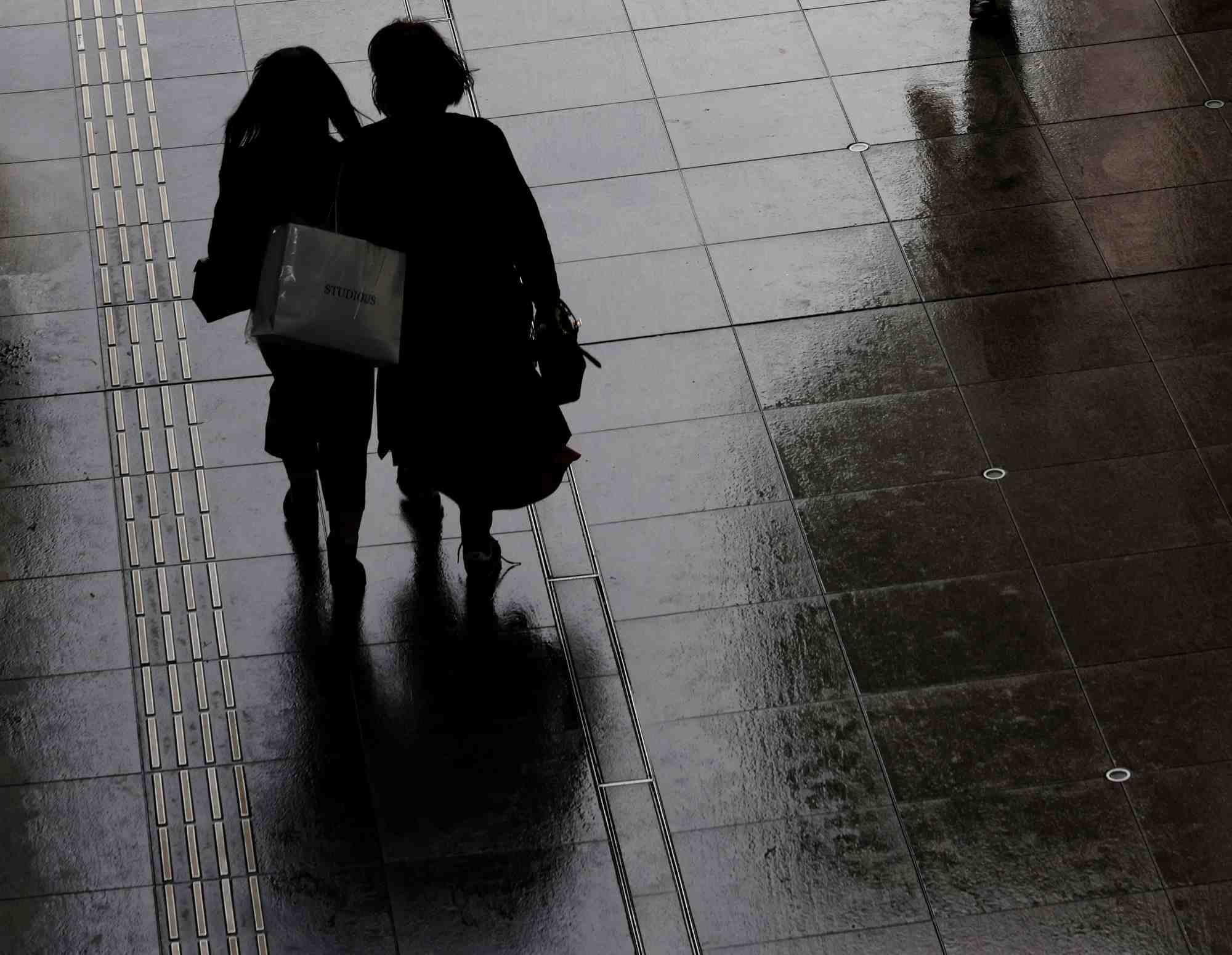 Des femmes portant un sac de courses dans un quartier commercant de tokyo