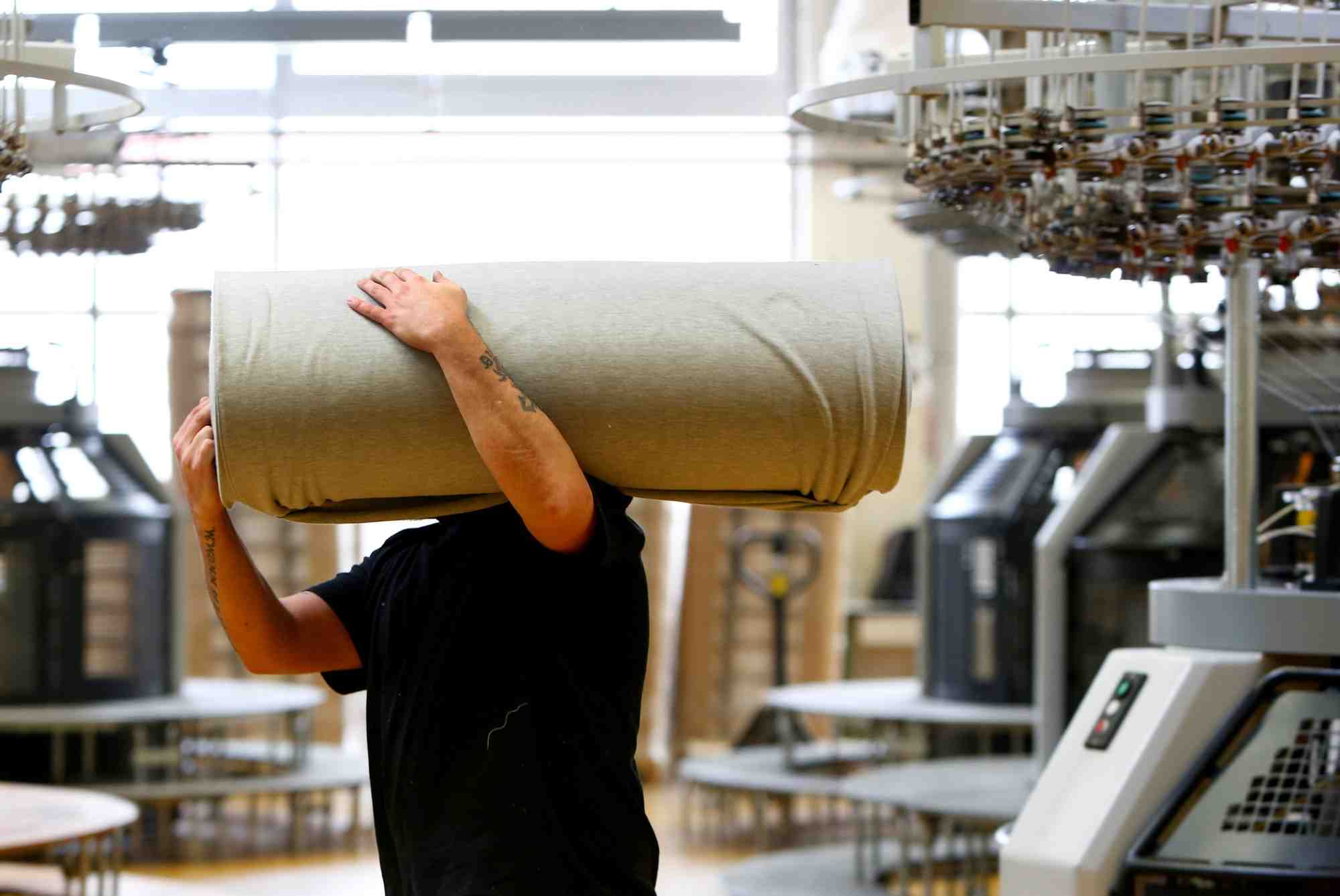 Un employe deplace des draperies dans l'usine de l'entreprise textile "trigema" a burladingen