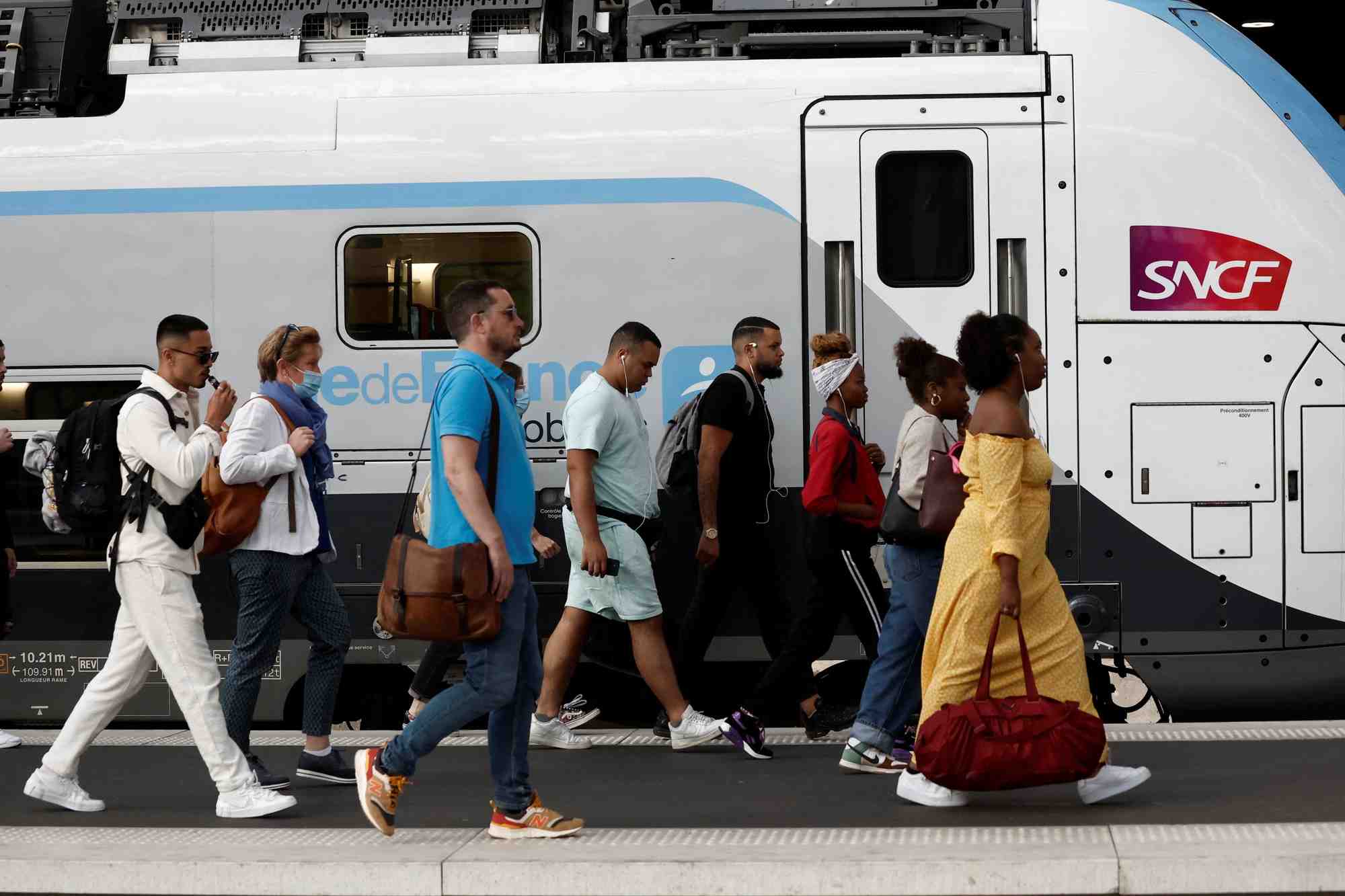Des voyageurs marchent sur une plateforme a la gare de lyon, a paris, en france