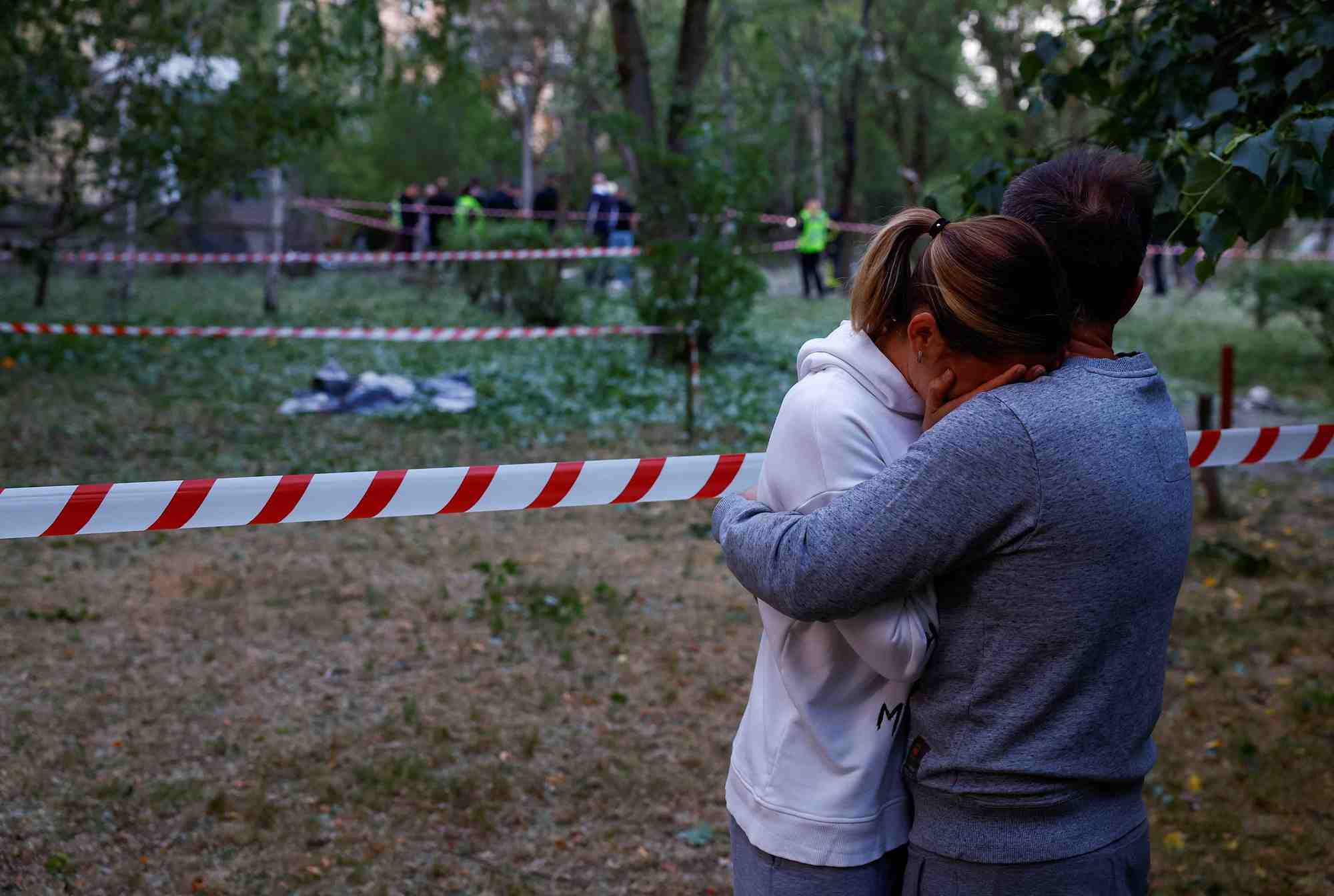 Photo de residents locaux pres du corps d'une personne tuee lors d'une frappe de missile russe a kyiv