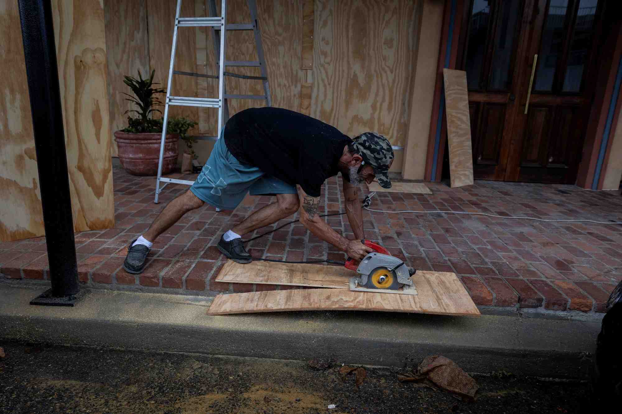 Un homme prepare sa maison pour l'arrivee de la tempete tropicale francine
