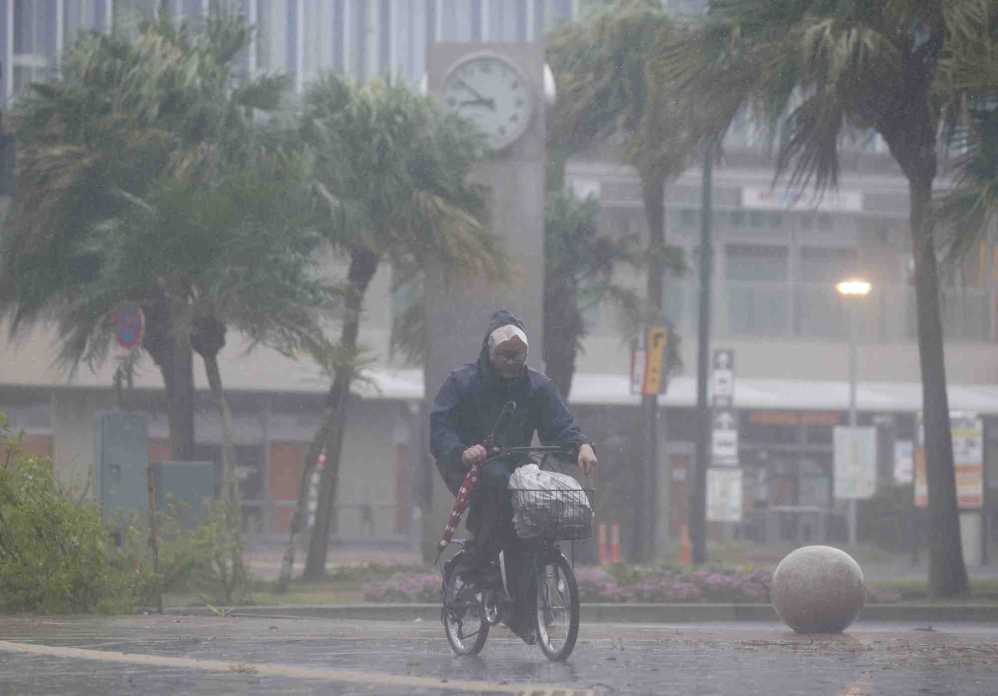 Un homme a velo passe sous les fortes pluies et le vent provoques par le typhon nanmadol a miyazaki