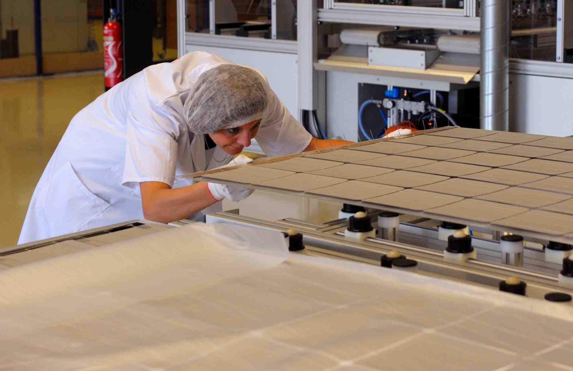 Un ouvrier construit un panneau solaire dans une usine a sainte marguerite, dans l'est de la france