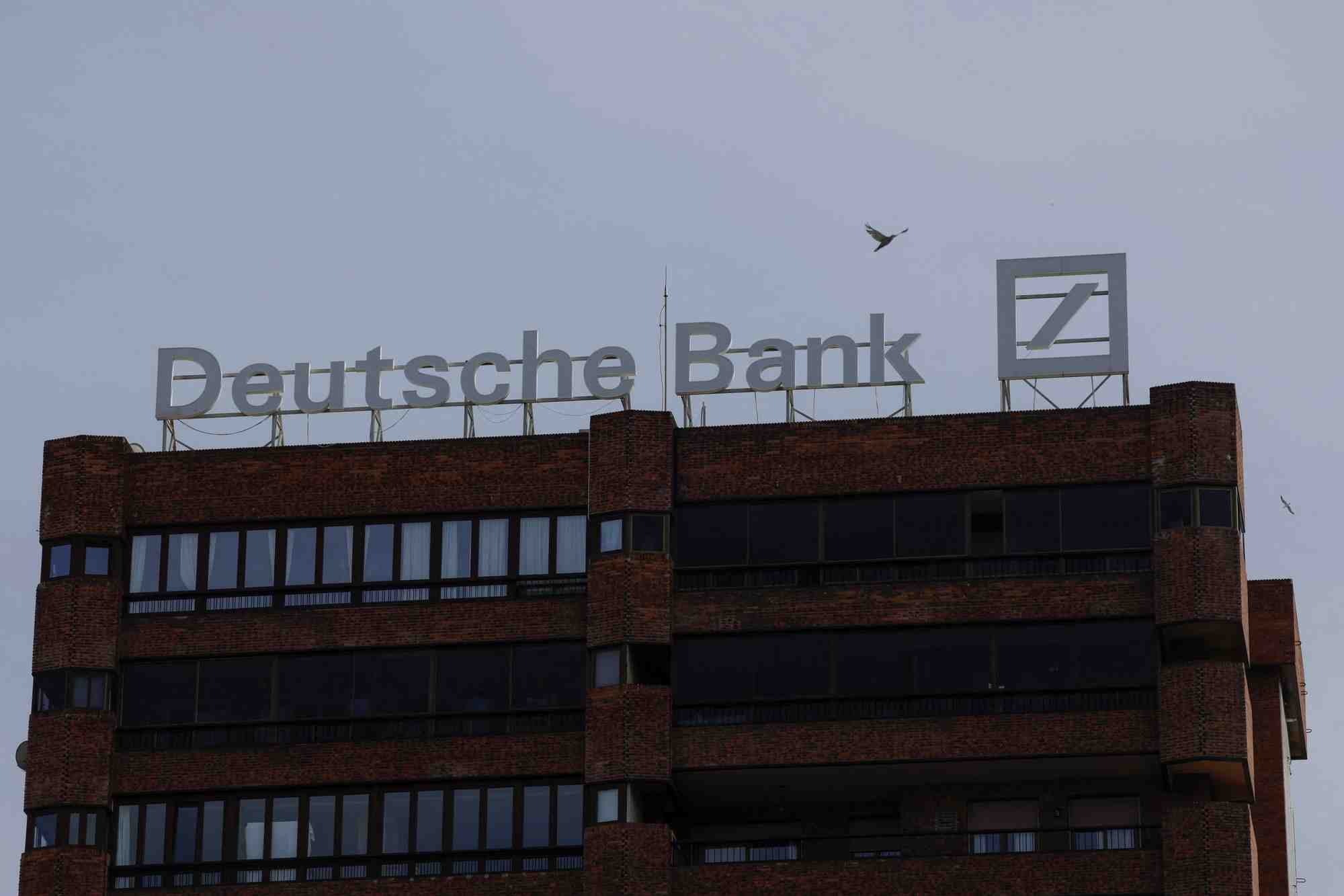 Le logo de deutsche bank est visible sur le toit d'un batiment a l'exterieur d'une agence de la deutsche bank a malaga
