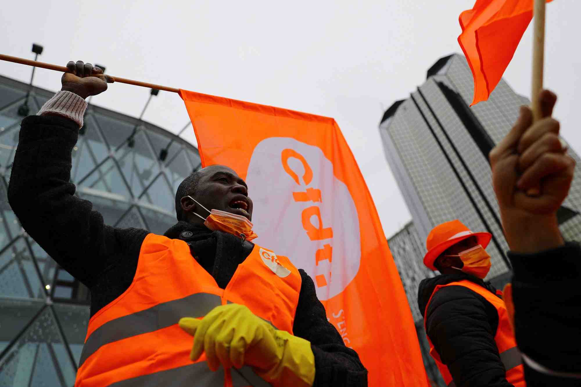 Des travailleurs tiennent des drapeaux du syndicat cfdt lors d'une manifestation a paris
