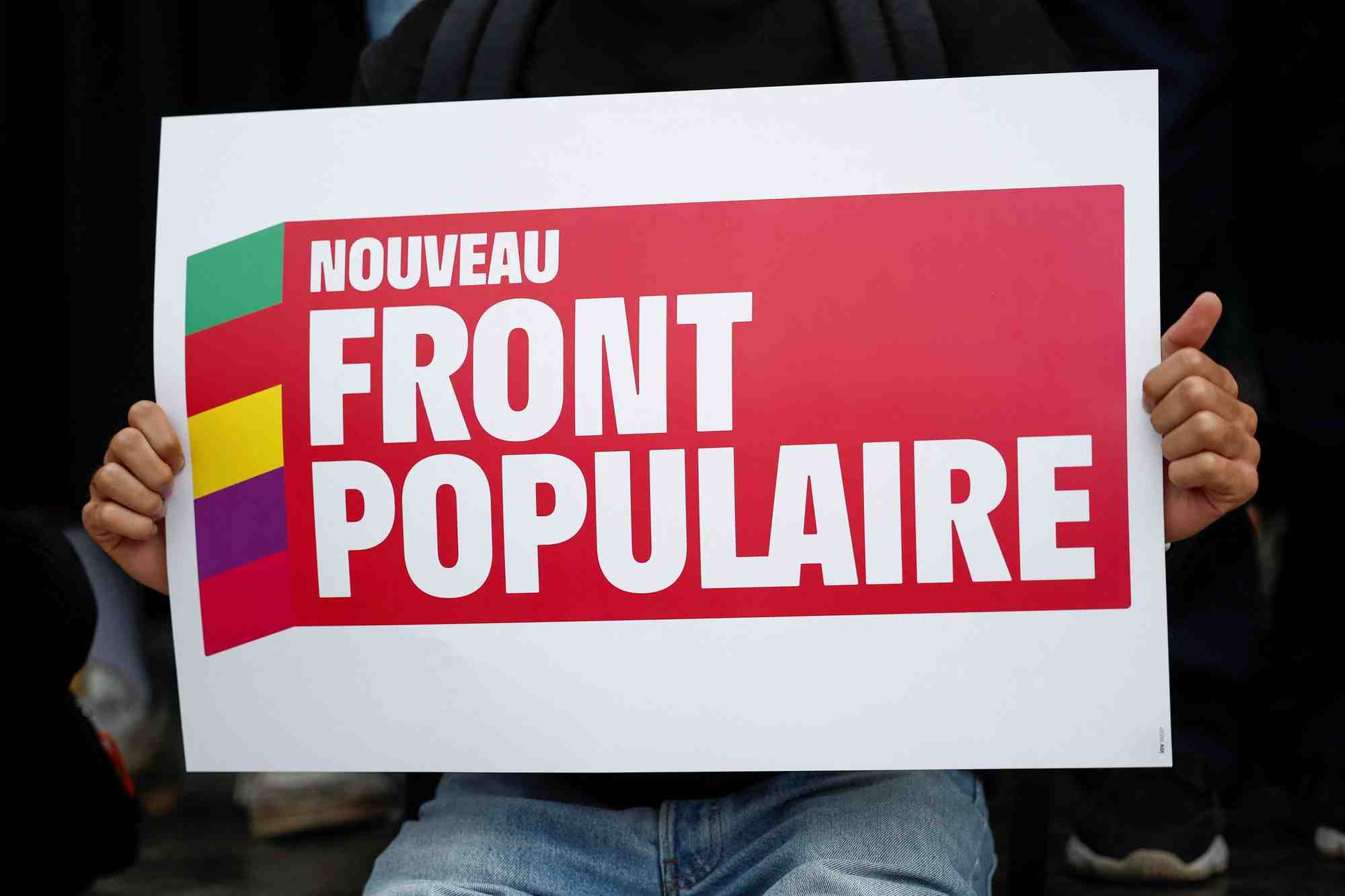 Une personne tient une pancarte avec le logo du nouveau front populaire (nfp)
