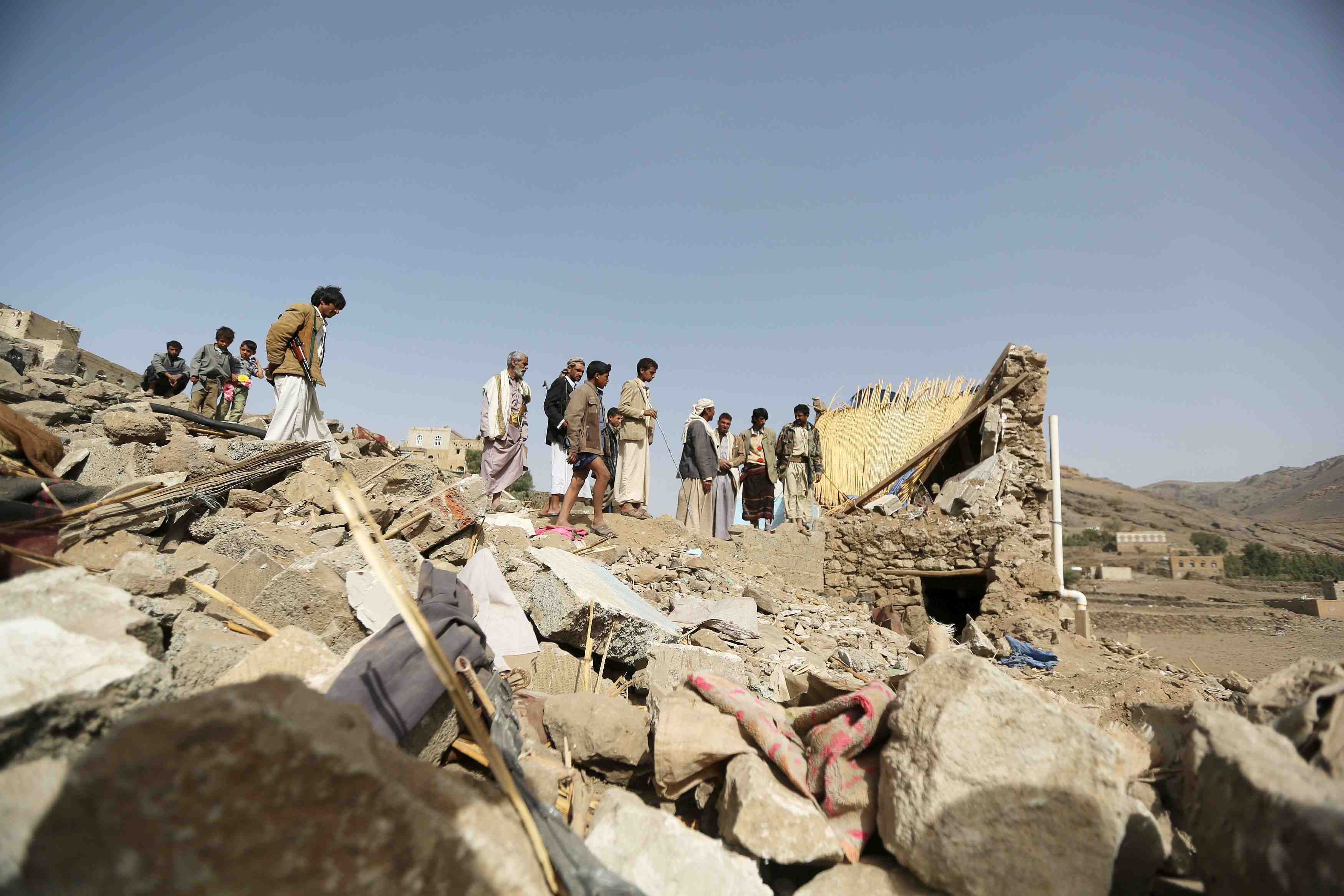 People gather on the wreckage of a house destroyed by an air strike in the bait rejal village west of yemen's capital sanaa