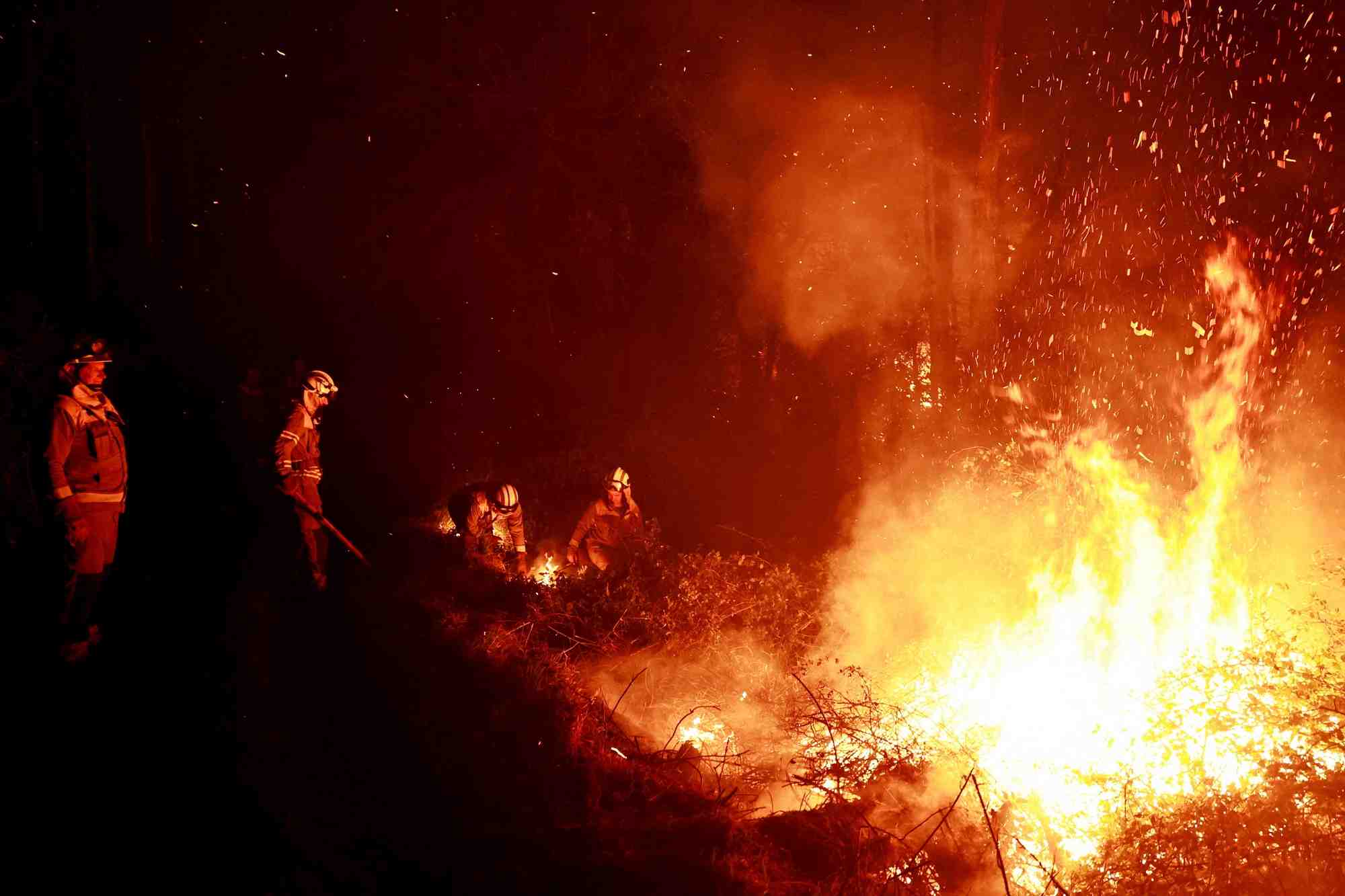 Les pompiers galiciens s'attaquent aux flammes dans une foret lors de feux de foret, a piedrafita, en espagne