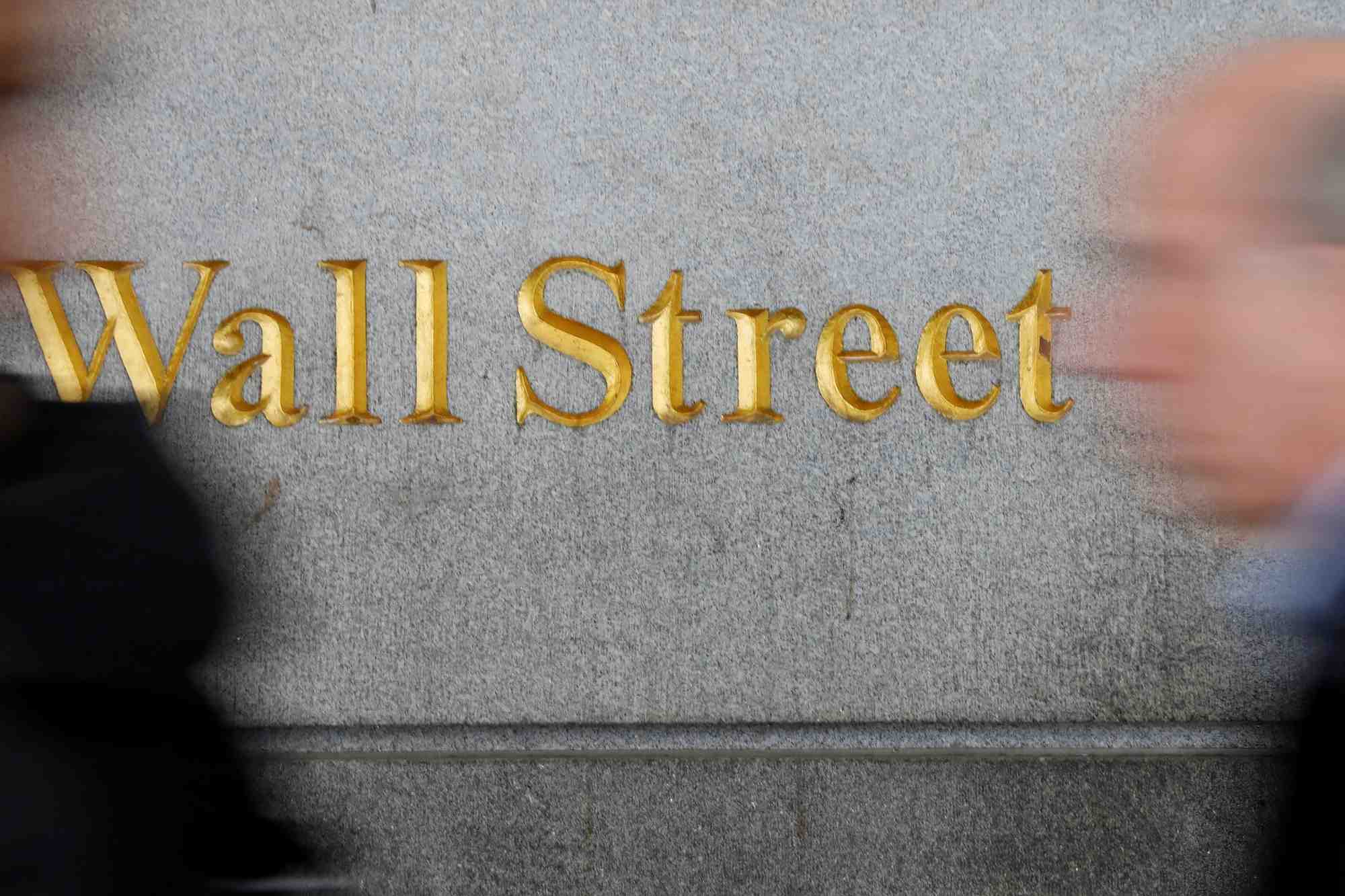 Photo d'archives: des personnes passent devant un panneau de wall street a proximite de la bourse de new york