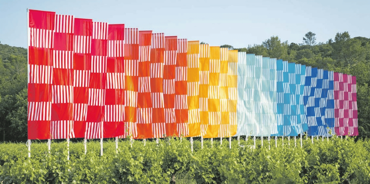 « L’échiquier arc-en-ciel ondulant », œuvre de 2016 signée Daniel Buren, installée dans les vignes du domaine de Peyrassol en juin 2021.