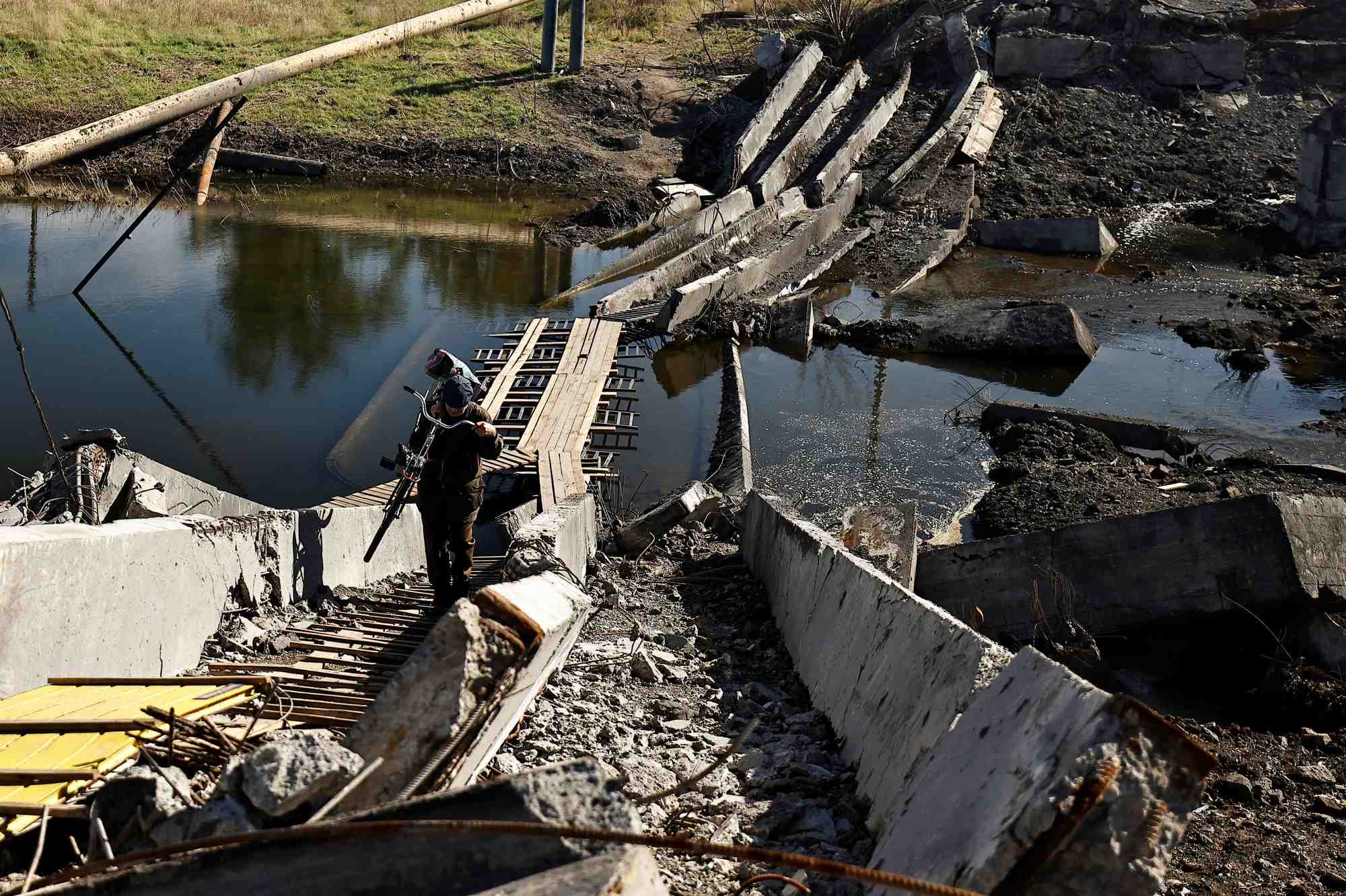 Un homme a traverse un pont detruit a bakhmut, region de donetsk en ukraine