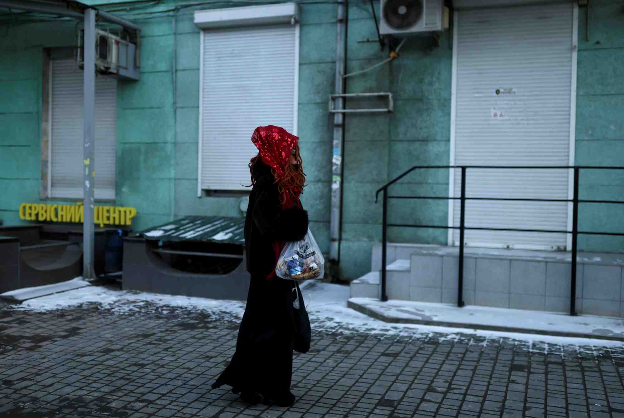 Une femme porte un sac avec de la nourriture alors qu'elle marche dans une rue a odessa, ukraine
