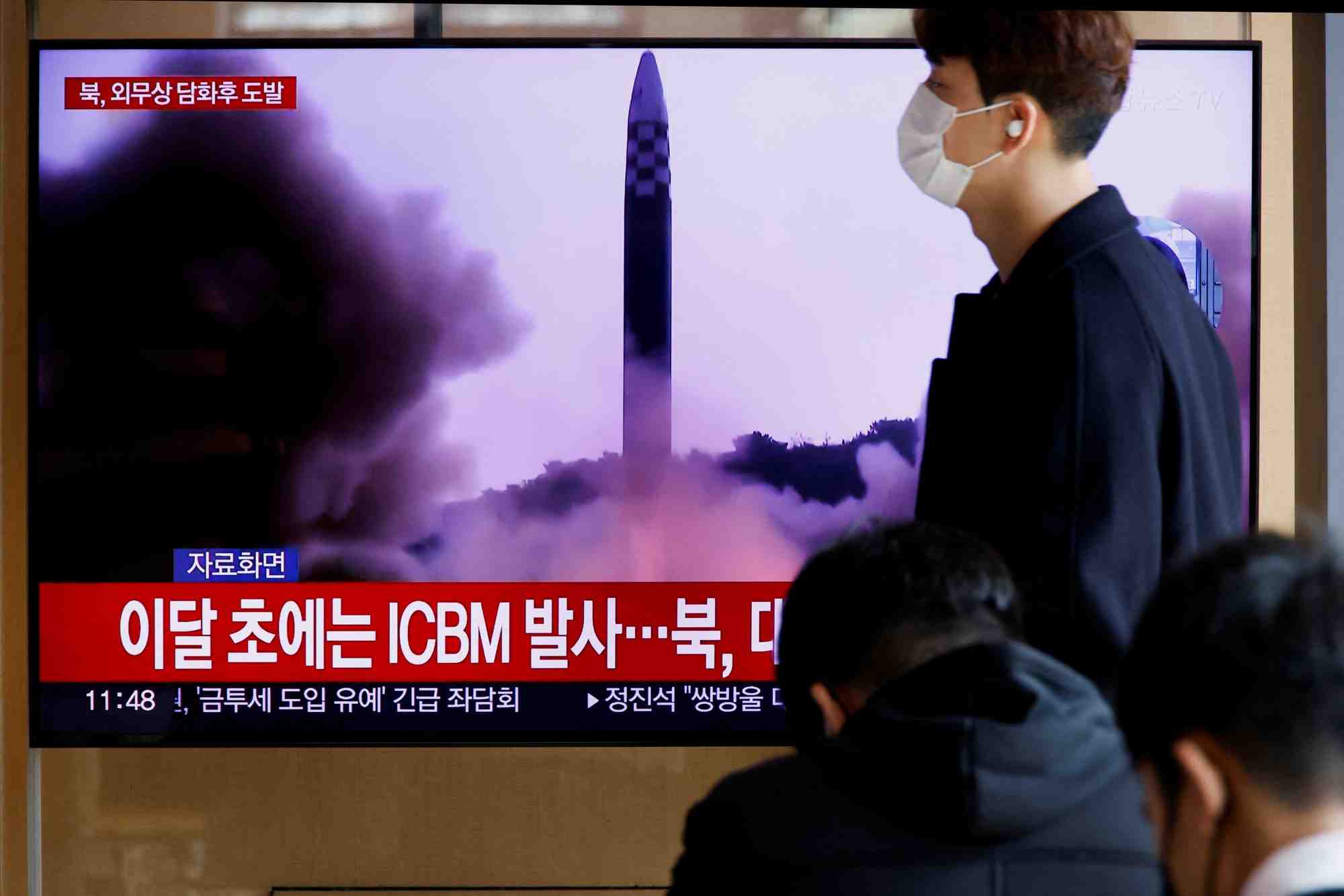 Un homme passe devant une television diffusant un bulletin d'information sur le tir par la coree du nord d'un missile balistique au large de la cote est sud-coreenne
