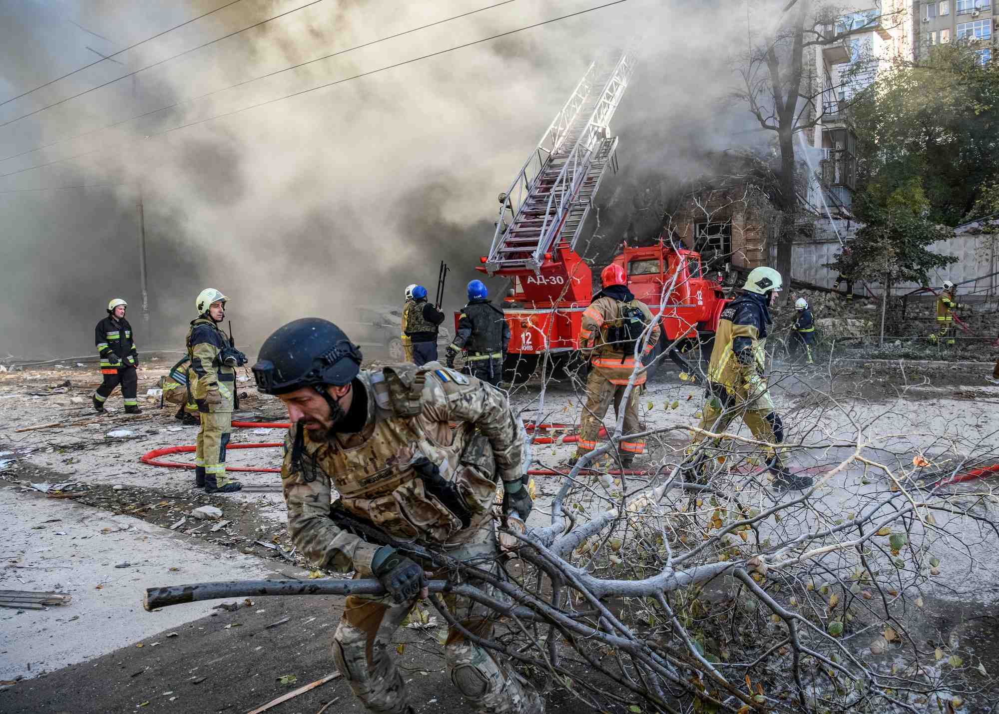 Des pompiers aident a evacuer un immeuble detruit par une frappe de drone russe a kyiv, en ukraine