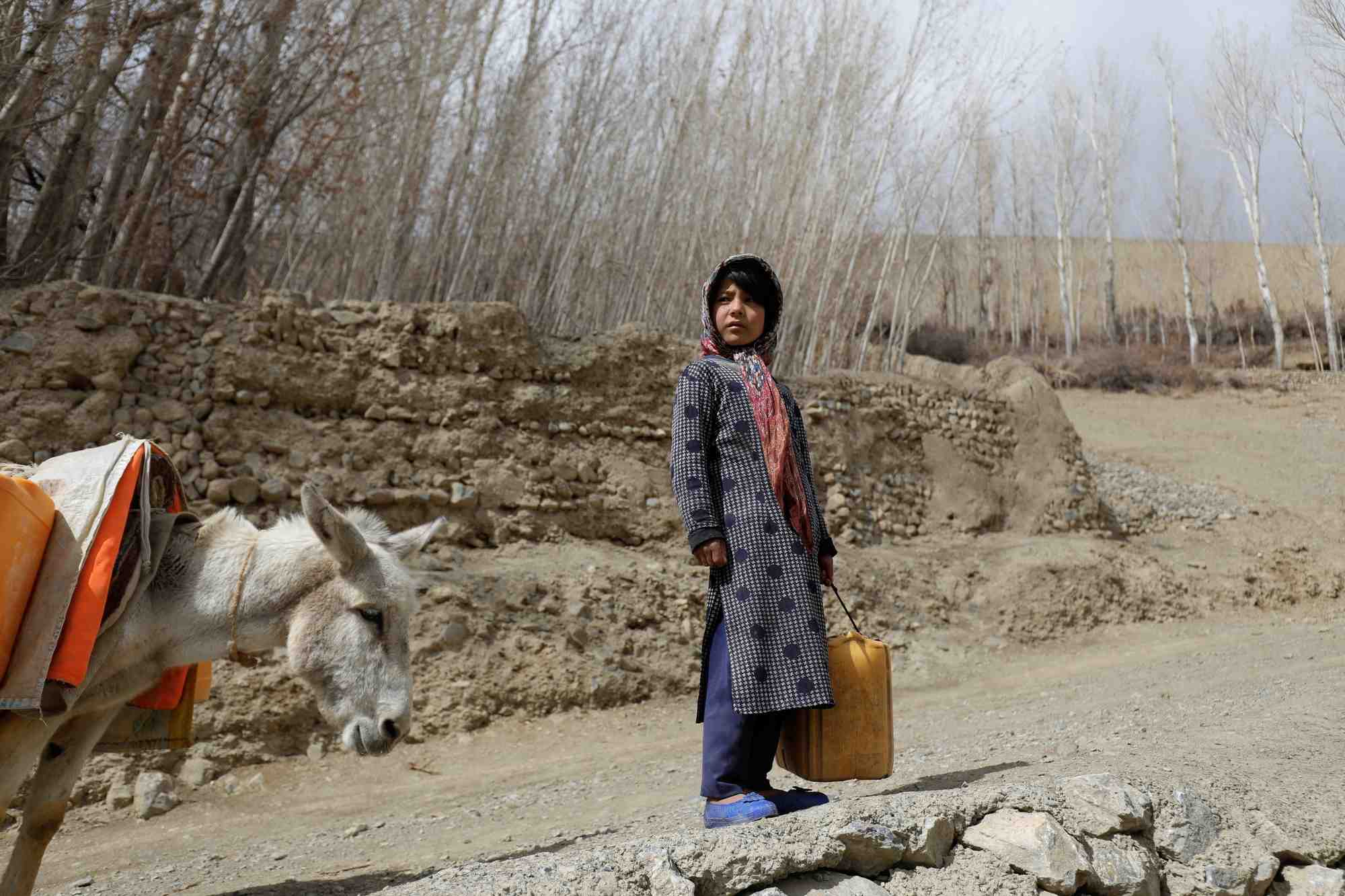 Une jeune fille avec un recipient d'eau vide, en afghanistan