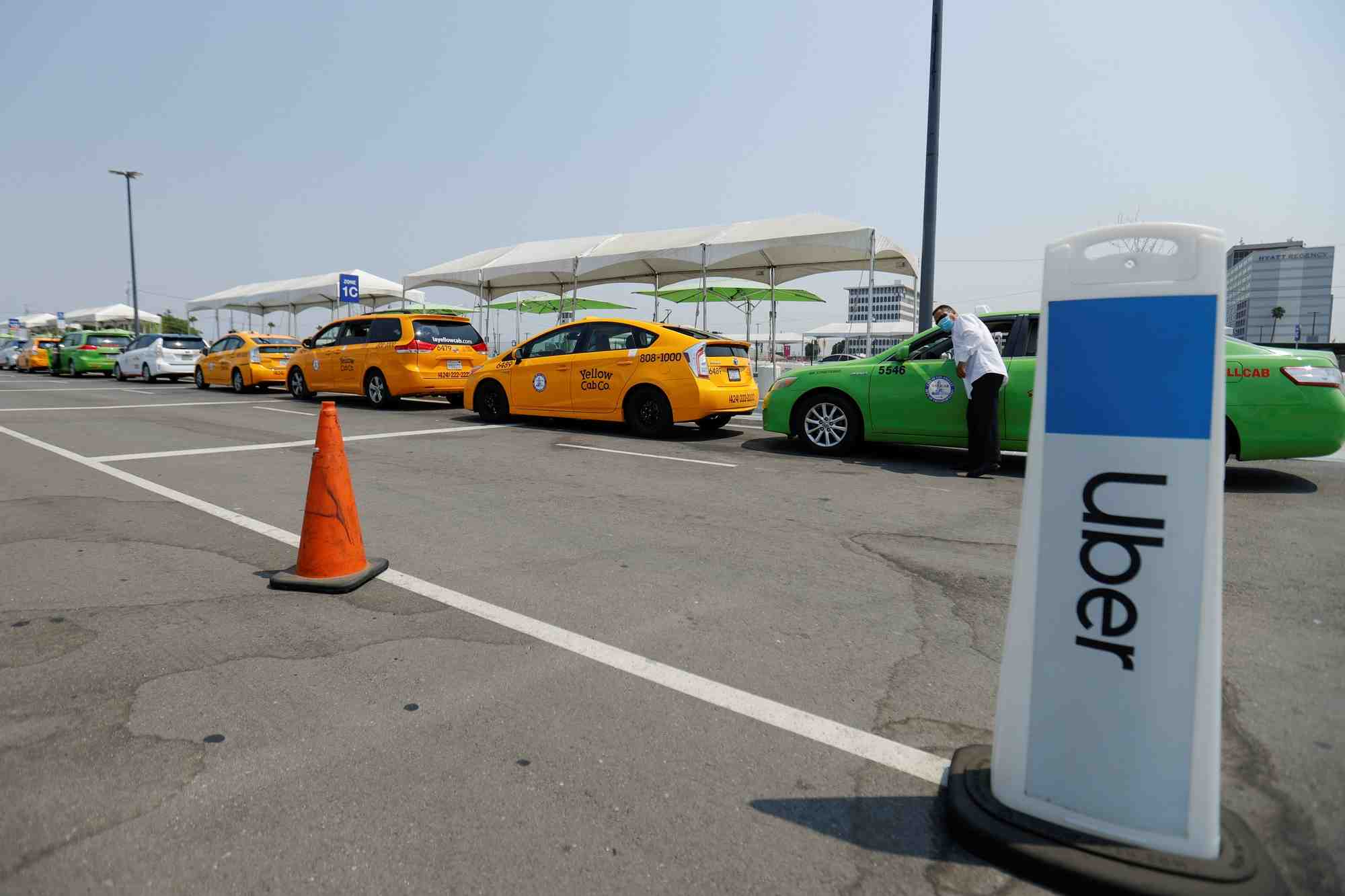 Des taxis font la queue a cote d'une zone de ramassage uber