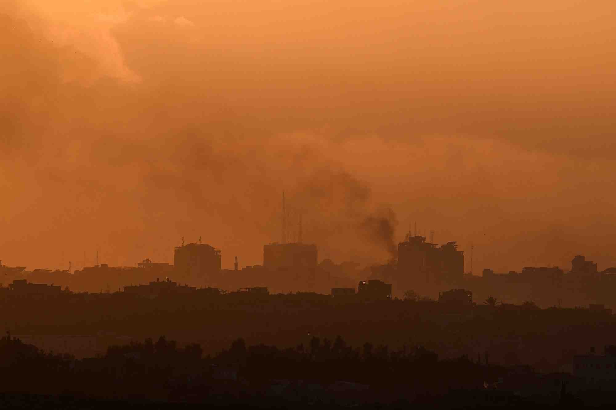 De la fumee s'eleve de gaza, alors que le soleil se couche, vue de sderot