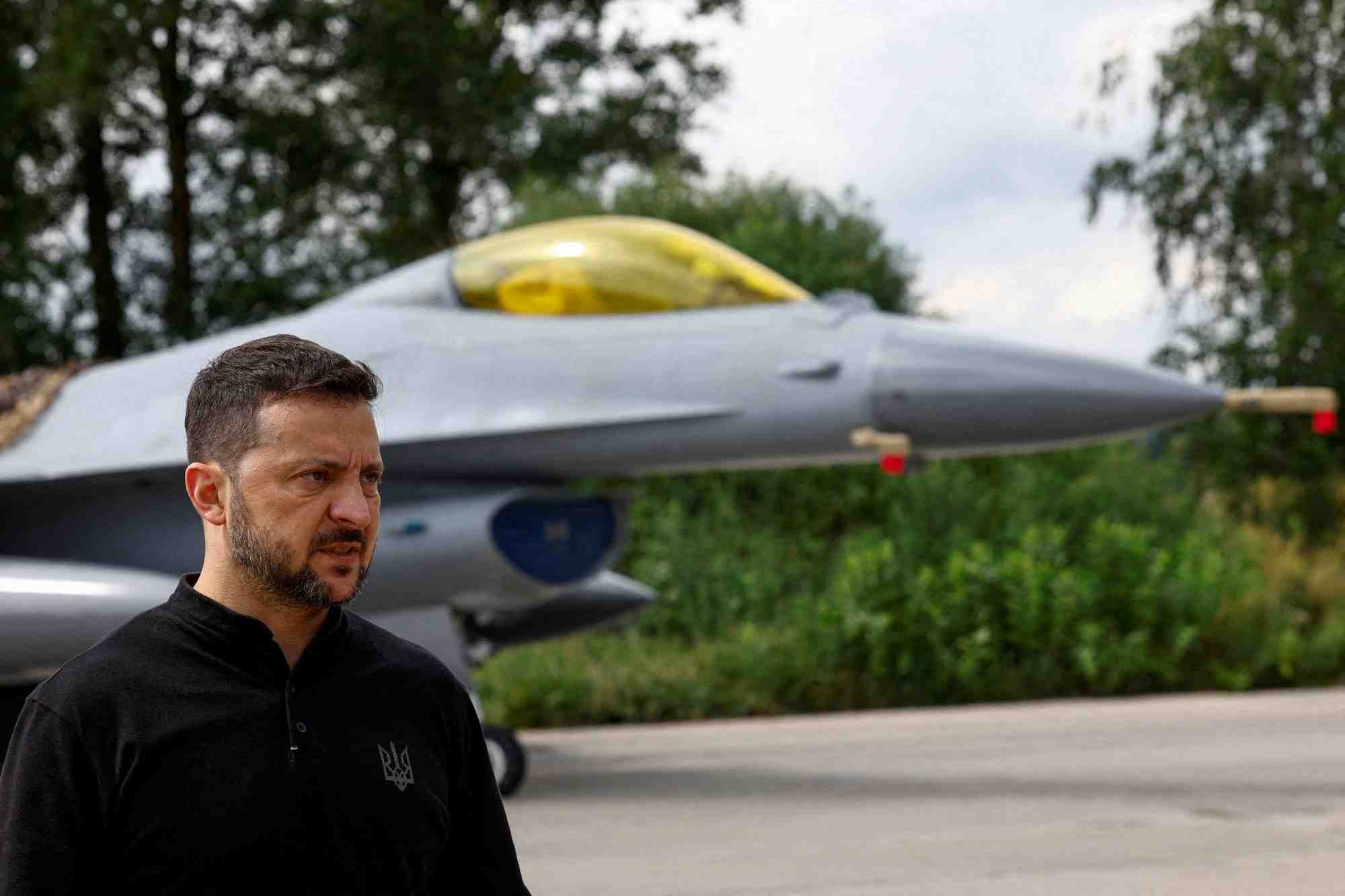 Le president ukrainien volodymyr zelenskiy devant un avion de combat f-16