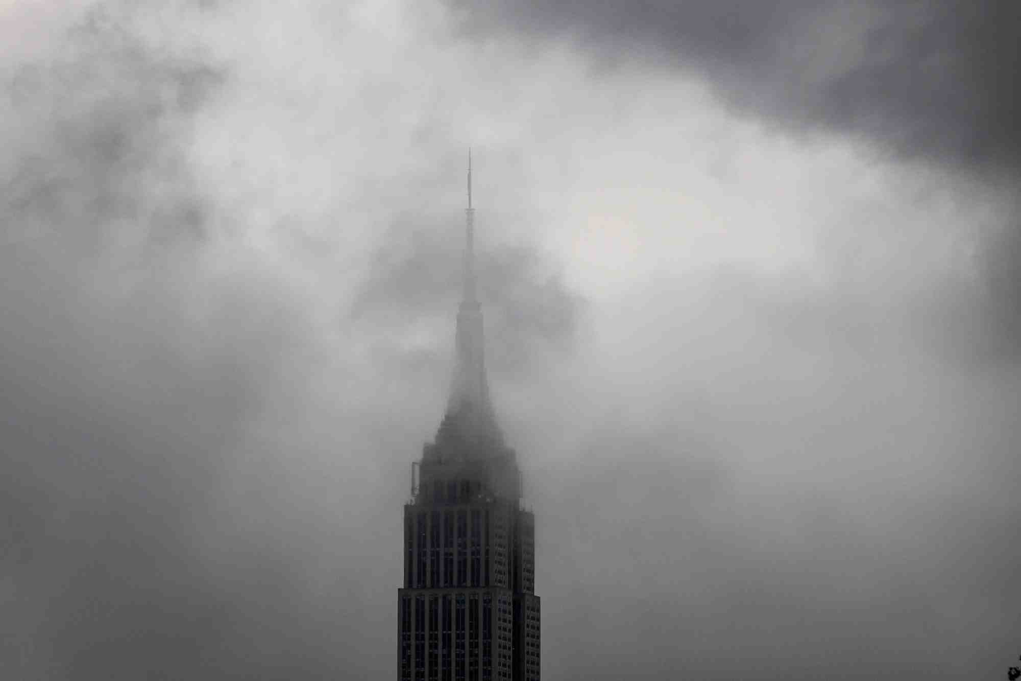 L'empire state building est couvert de brouillard par une matinee pluvieuse, vu depuis hoboken, dans le new jersey