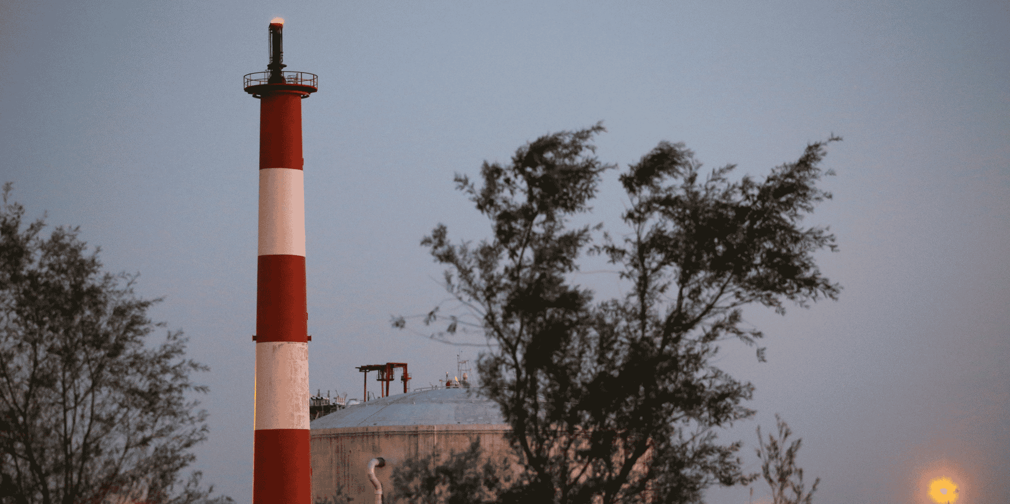 Une flamme brûle en haut d'une cheminée devant un terminal de stockage de méthane au Port de Nantes Saint-Nazaire à Montoir-de-Bretagne
