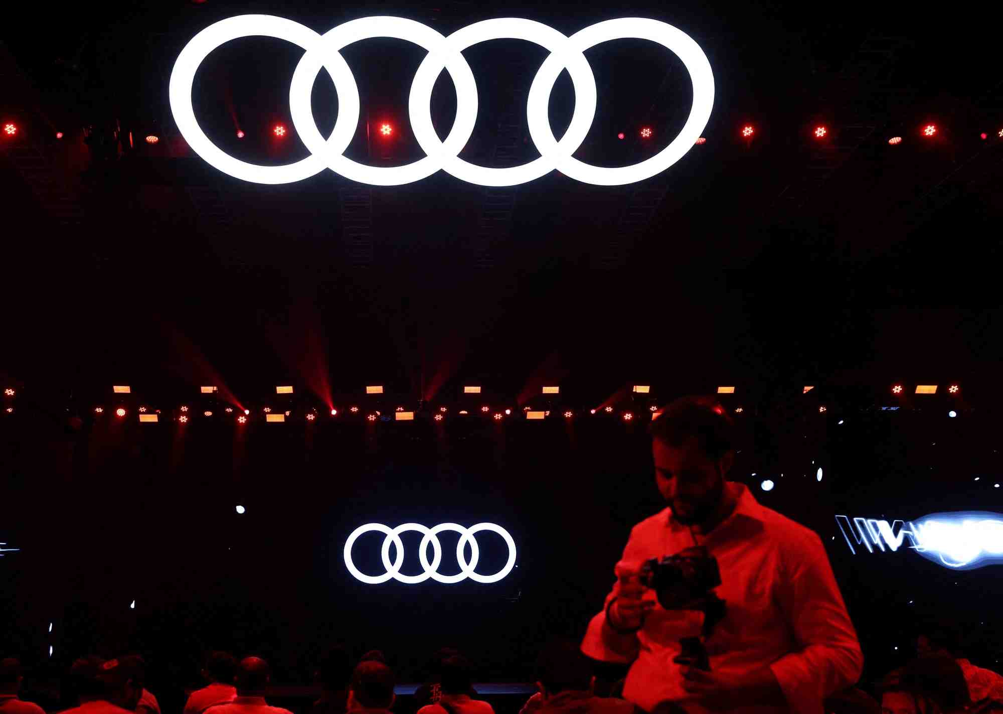A man walks past a logo of german automobile manufacturer audi ahead of the launch of the audi q8 e-tron and the audi q8 sportback e-tron electric suvs in mumbai