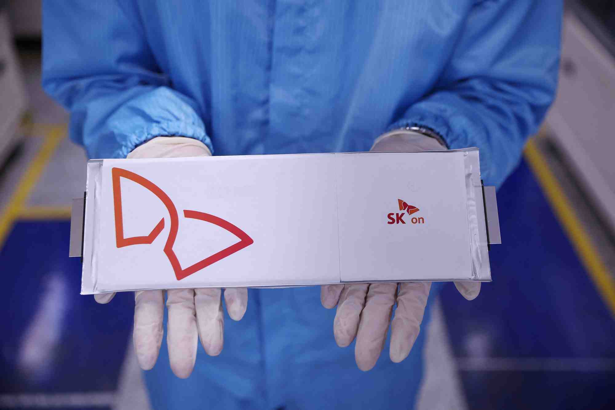 Un employe tient une cellule de batterie pour vehicule electrique dans l'usine de batteries de sk on a seosan