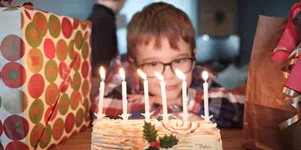 Un enfant devant une bûche de Noël