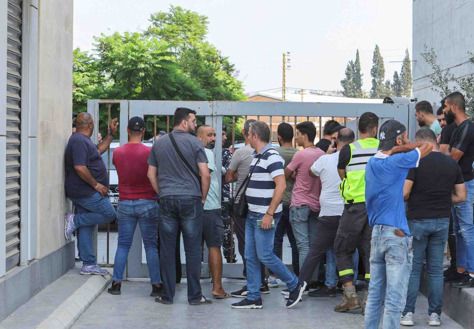 Des personnes se rassemblent devant une agence de byblos bank