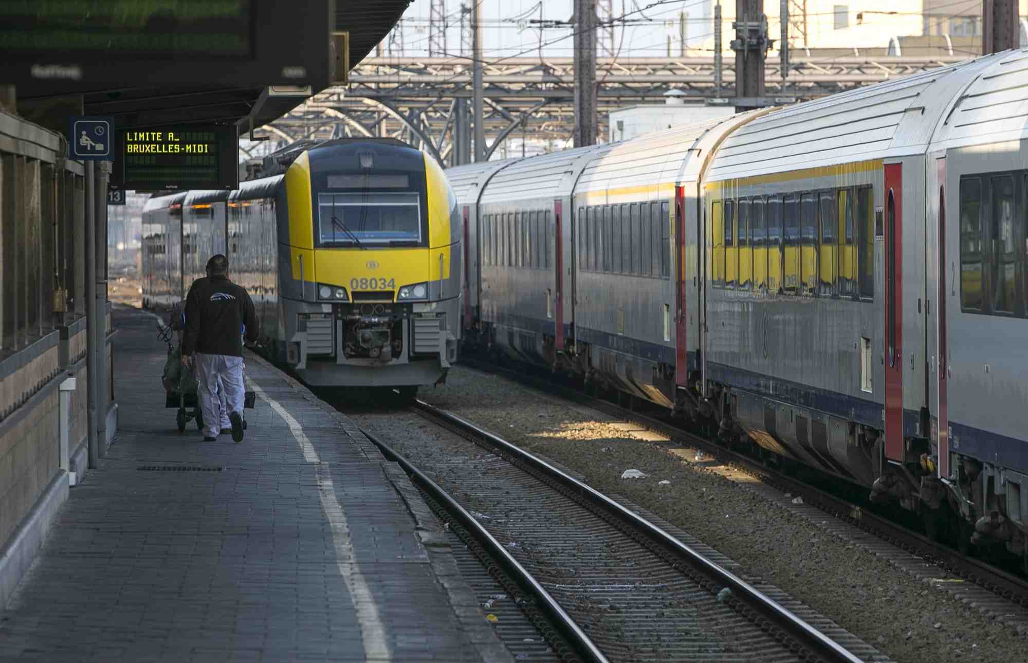 Un travailleur marche sur le quai d'une gare