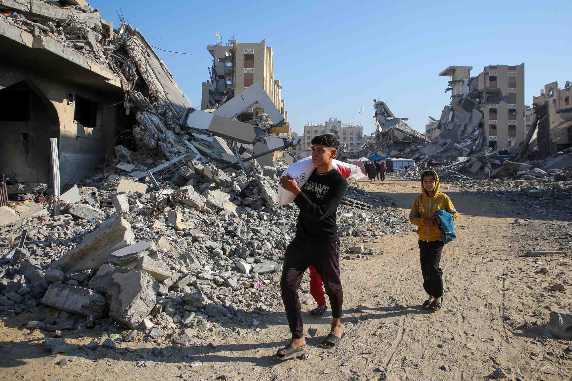 Des palestiniens recoivent des sacs de farine distribues par l'unrwa a khan younes, dans le sud de la bande de gaza