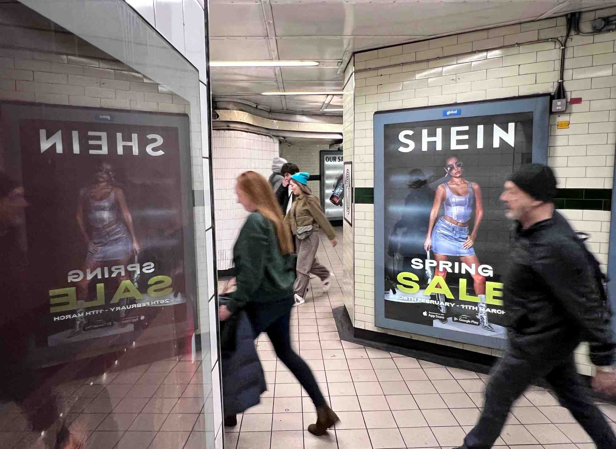 Des personnes passent devant une publicite pour shein a londres