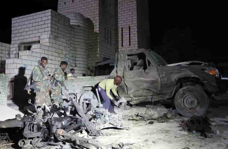 Somali soldiers and policemen inspect the scene of a suicide car explosion near the parliament in the capital mogadishu