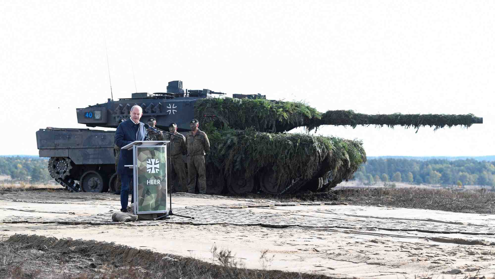 Le chancelier allemand olaf scholz prononce un discours devant un char leopard 2