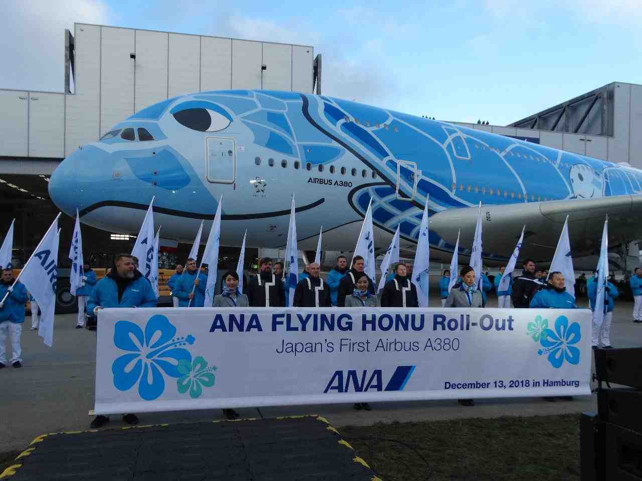 Les peintres (en blouson bleu) présentent la nouvelle livrée de l'A380 de ANA.