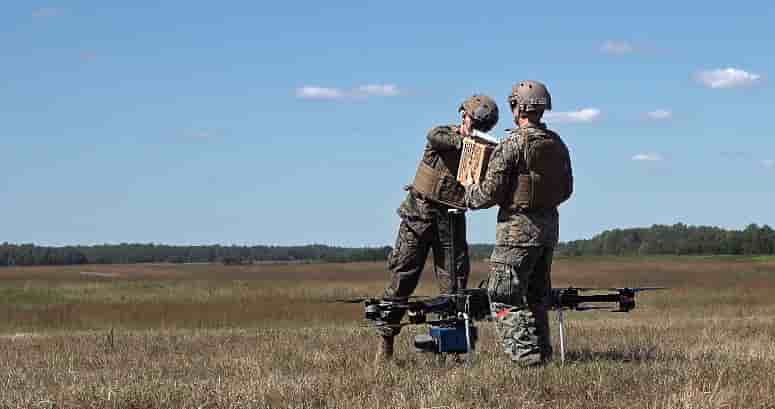 Deux soldats récupèrent le colis embarqué sur le drone.