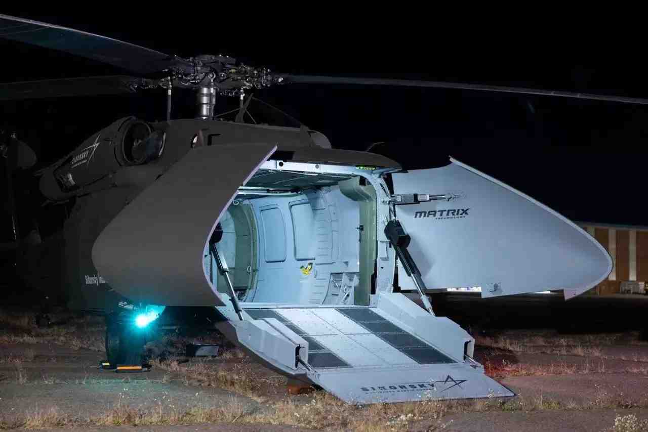 Hélicoptère de transport moyen autonome S-70UAS U-Hawk au sol avec sa rampe ouverte.