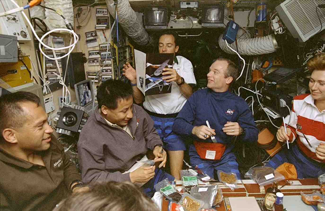 L'équipage “assis” autour de la table à manger du module de base de Mir.