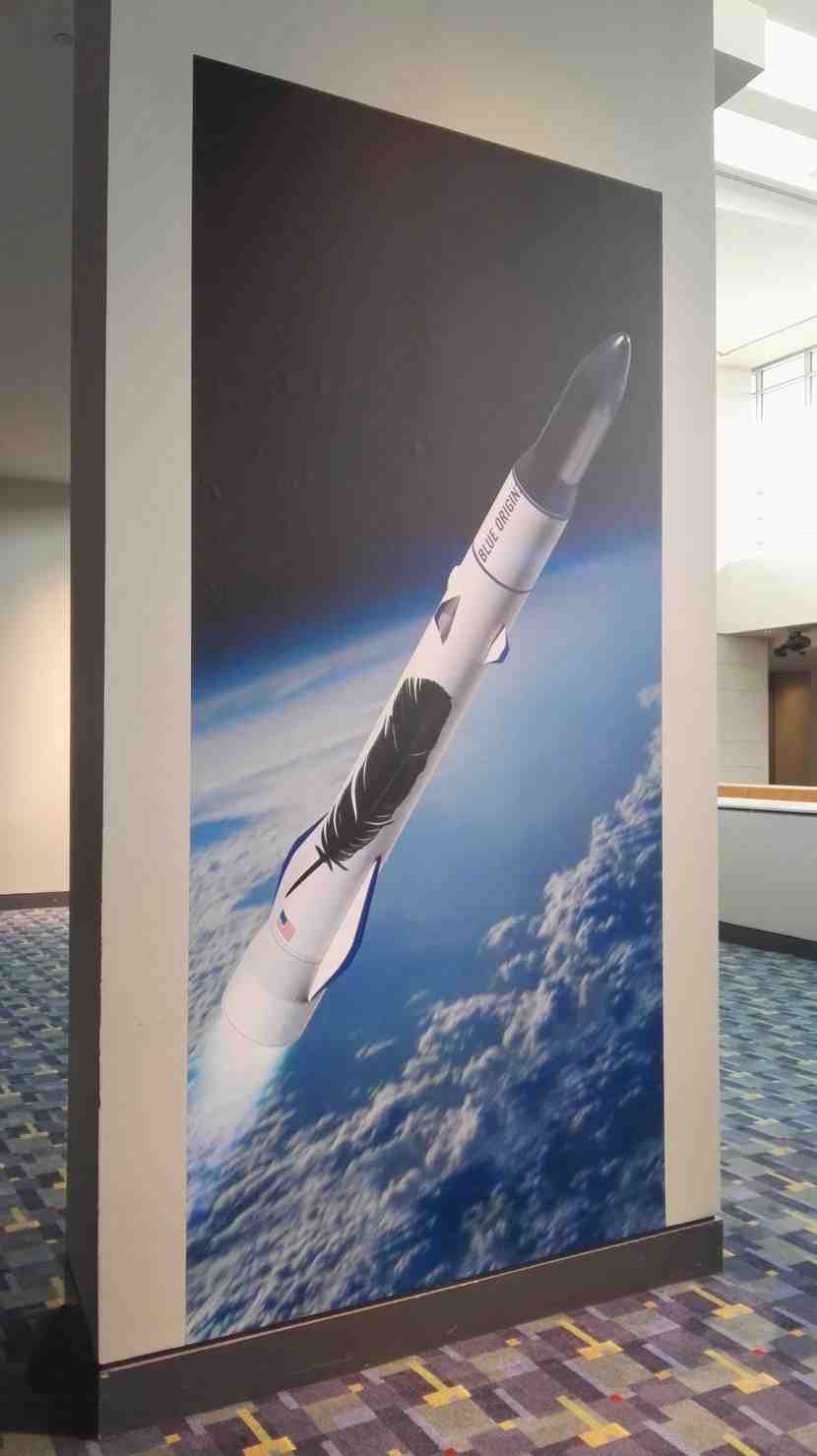 A la sortie de la conférence, de larges posters du New Glenn bi-étage recouvraient les murs du lobby du centre de conférences.