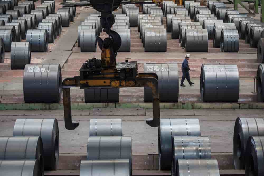 Un ouvrier passe devant des rouleaux de fer et d’acier à l’usine sidérurgique de Chongqing. (Photo d’archive)