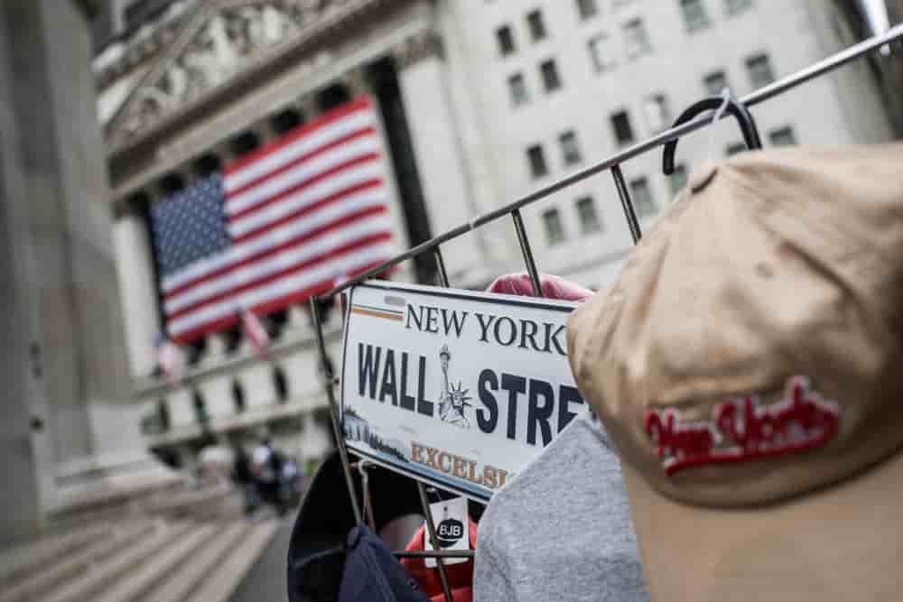 Une plaque de Wall Street est visible sur l'étal d'un vendeur de rue à l'extérieur de la Bourse de New York (NYSE) à New York, États-Unis.