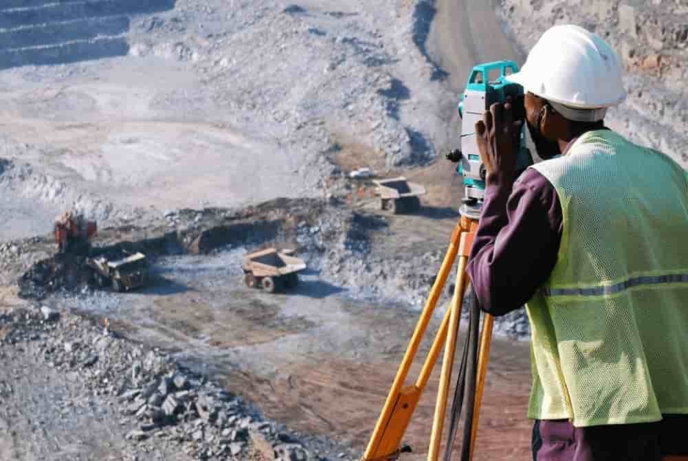 Géomètre utilisant un théodolite sur un site minier