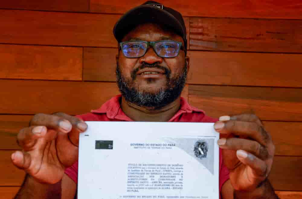 Aurélio Borges, chef d'une communauté quilombola, pose pour des photos avec une copie du titre de propriété du territoire de sa communauté, délivré par l'État du Pará.