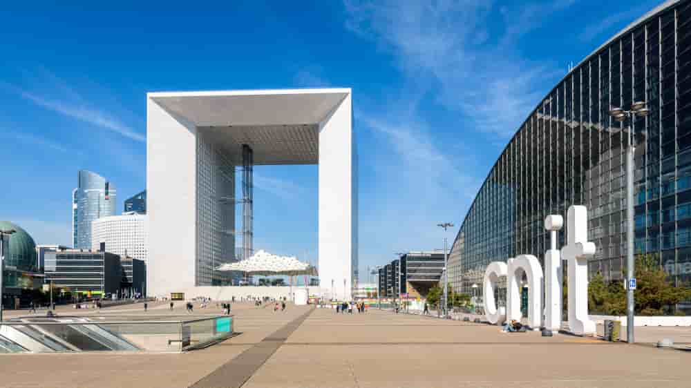 Puteaux, France - April 9, 2023: Panoramic view of the parvis de la Defense with La Grande Arche and CNIT buildings in La Defense business district on a sunny day. - La Grande Arche and CNIT buildings in La Defense business district. - Puteaux, France...