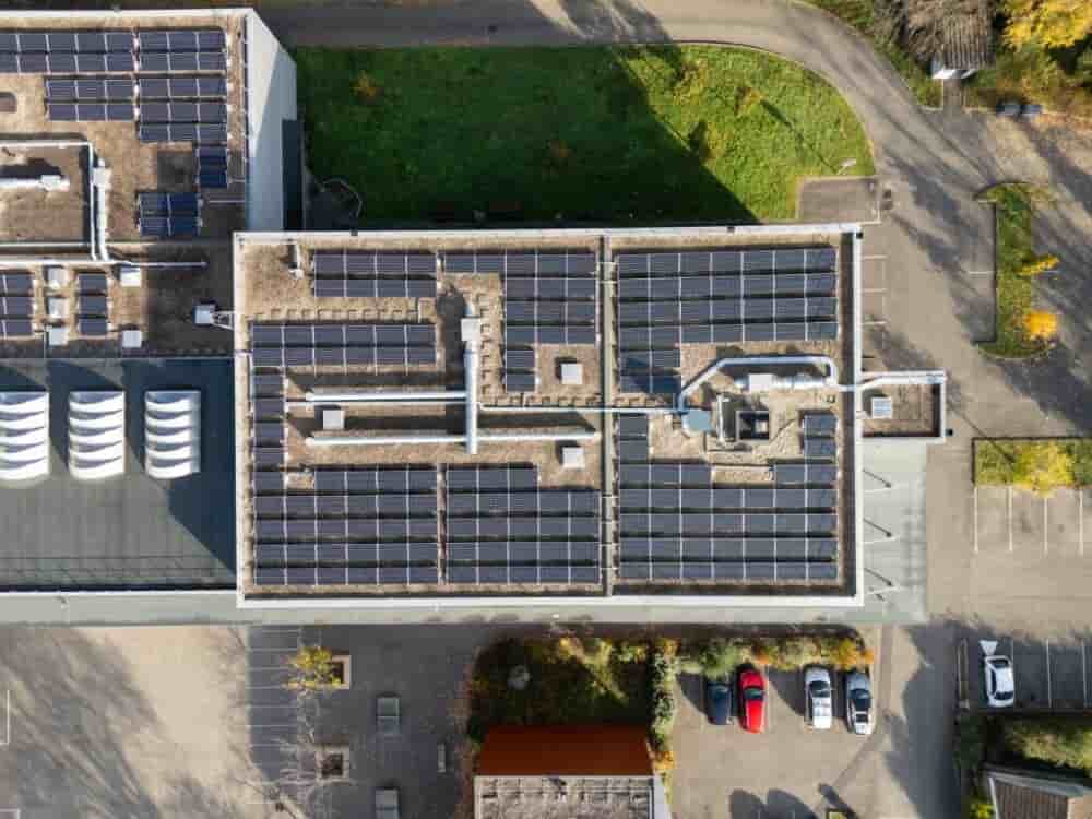 Vue aérienne de panneaux photovoltaïques installés sur le toit d'une école à Lyon.