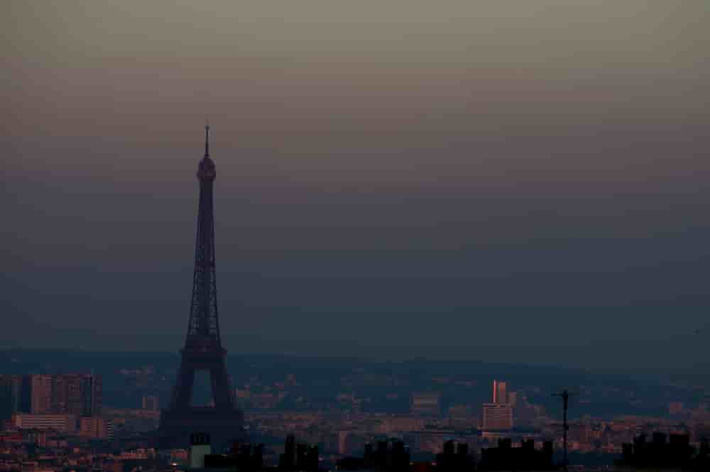 La tour Eiffel entourée d'un voile de particules fines surplombant la ligne d'horizon de Paris, France, le 26 juin 2024.