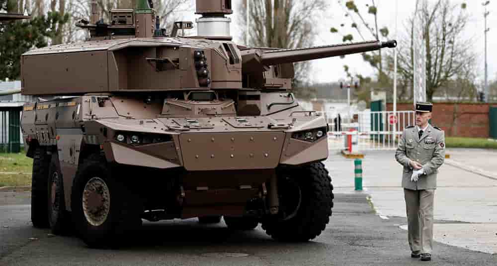 Un officier marche à côté d'un véhicule blindé de combat Jaguar.
